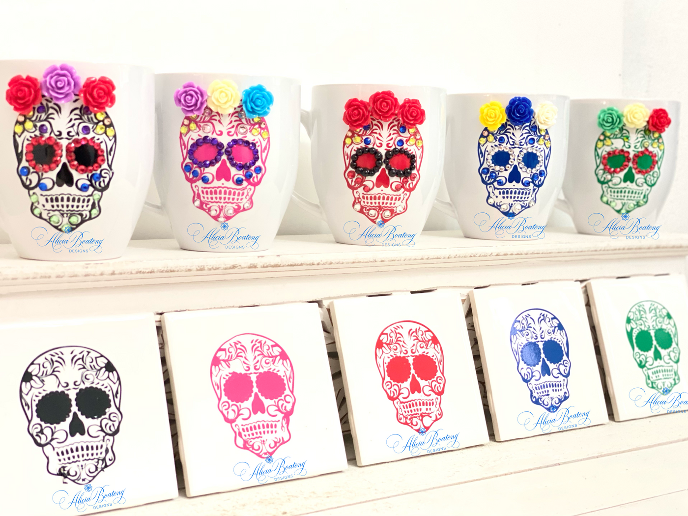 Beautifully decorated sugar skulls to celebrate el Dia de los Muertos. Adorned with colored gems, porcelain rosettes and adhesive vinyl.